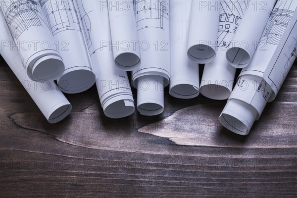 Pile of blueprint rolls on pine wooden vintage board maintenance concept