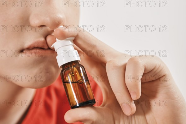 Blond Boy drips nose drops from runny nose. Treatment of colds and allergic rhinitis. Selective focus
