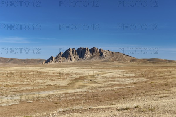 Rock formation on the horizon in the steppe landscape of the Gobi Desert, Mongolia, Central Asia