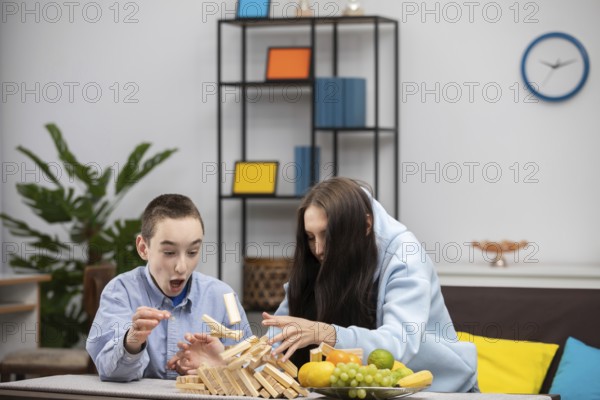 Eine Gruppe von Kindern ist mit einem spannenden Jenga-Spiel beschäftigt, bei dem sie ihre Fähigkeiten unter Beweis stellen