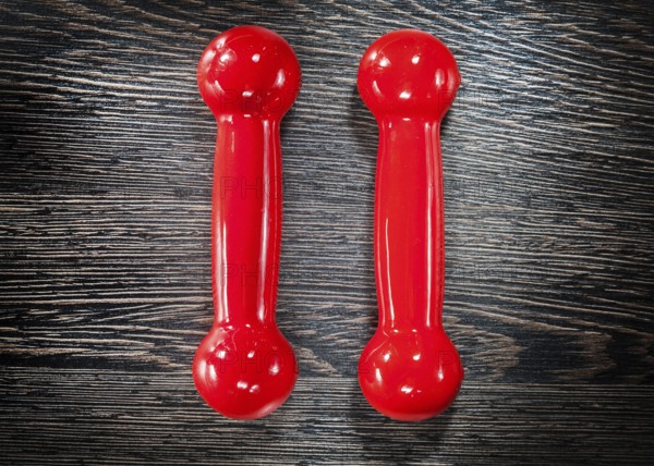 Red dumbbells on vintage wooden board