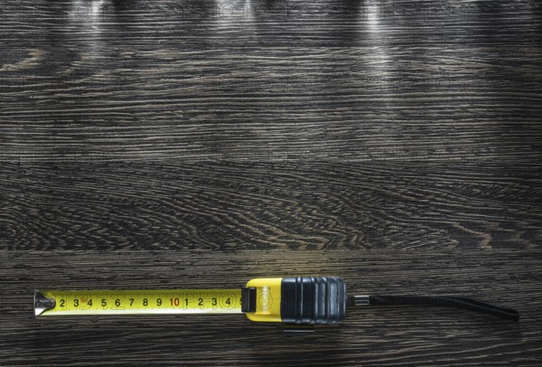 Rolled tape measure on vintage wooden board