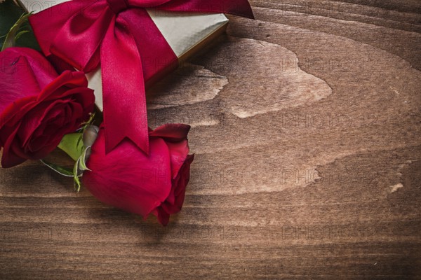 Wrapped present with red ribbon natural bloomed roses holiday concept