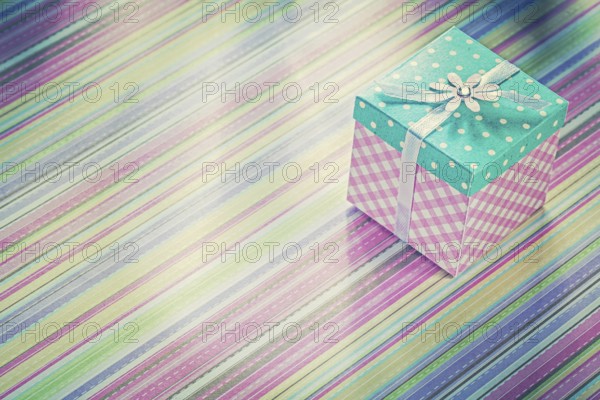 Wrapped present box on stripy fabric background holidays concept
