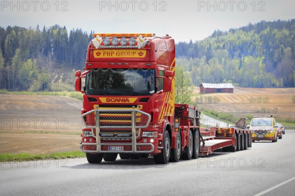 Scania truck of PHP Group in front of gooseneck trailer returns from delivering oversize load, followed by escort vehicle. Salo, Finland. May 15, 2021