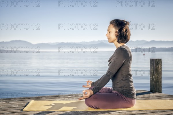 A pretty woman doing yoga at the lake