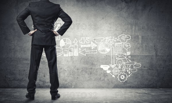 Back view of confident businessman in empty concrete room