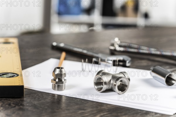 Water braided metal hose and hosepipe fittings laying on table. Close up flexible hydraulic system. Plumbing pipeline spare parts. Professional plumbing services, repair and renovation