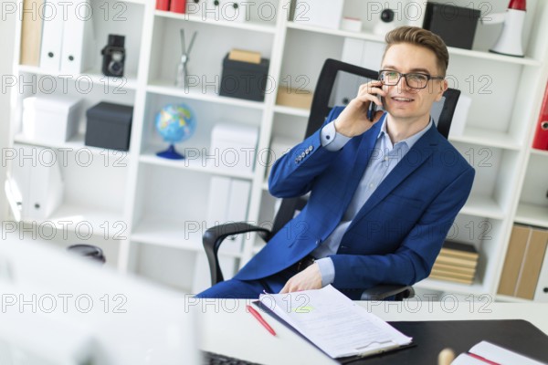 Casual businessman working in office, sitting at desk, typing on keyboard, looking at computer screen