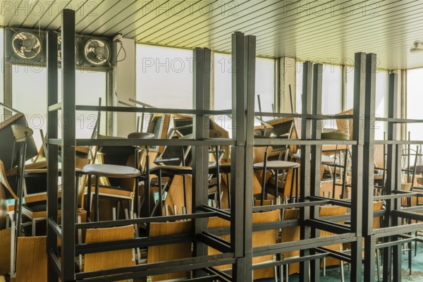 Goesan, South Korea. May 29, 2020: Chairs and tables stacked haphazardly in sunlit room of bankrupt resort