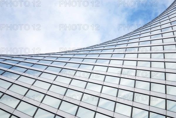 Abstract modern architecture, glass exterior structure, wave shape building detail in blue sky