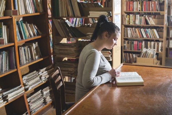 Student girl in a library. Looking at book