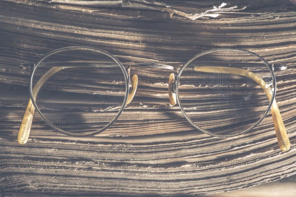 Old vintage round glasses and old book. Low light