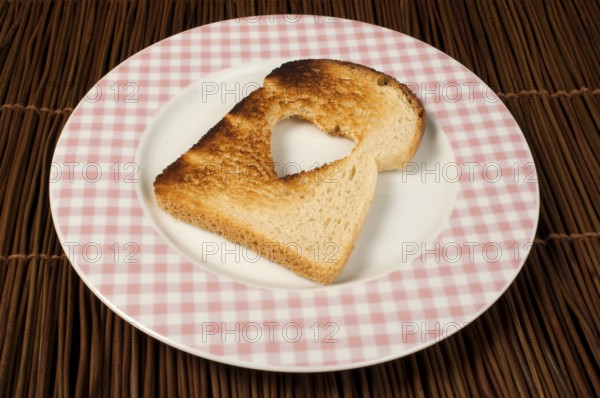 Toast with heart-shaped set in white plate