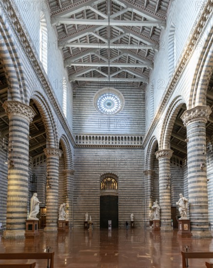 Orvieto, Italy, 18 November, 2023: interior view of the Orvieto Cathedral central nave with pews and many statues