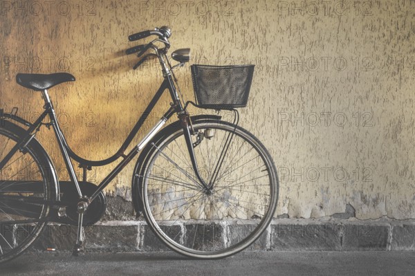 Vintage bicycle leaning against a wall. Retro style photo