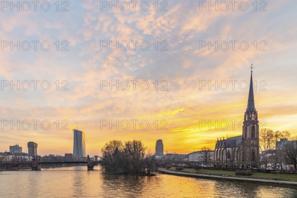 View across the River Main to the ECB and the Protestant Church of the Epiphany. Sunrise in the background of the buildings. Taken in the morning in Frankfurt am Main