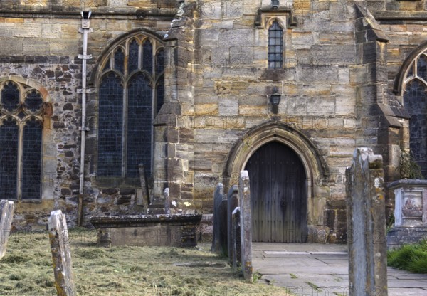 The oldest part of the St Laurence church in HawkhurstKent the lower part of the tower dates from the 12th Century. Following the destruction during the Border Wars came 14th Century rebuilding, and restoration in the 17th, 18th and 19th Centuries. Work from all these periods can be seen. Here we see the entrance with tombstones in the front