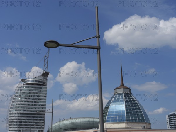 Modern buildings with glass facades under a blue sky with some clouds and lanterns in the foreground, bremerhaven, bremen, germany