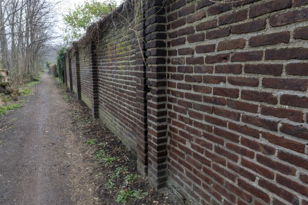 Brick wall between street and od industrial area