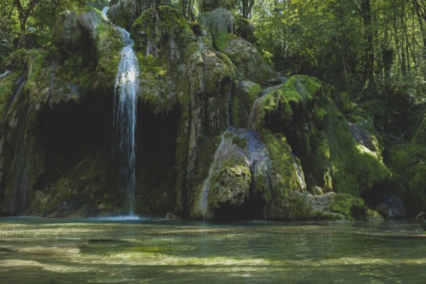 The tufa waterfall near Arbois. Crystal clear waterfall, powerful waterfall