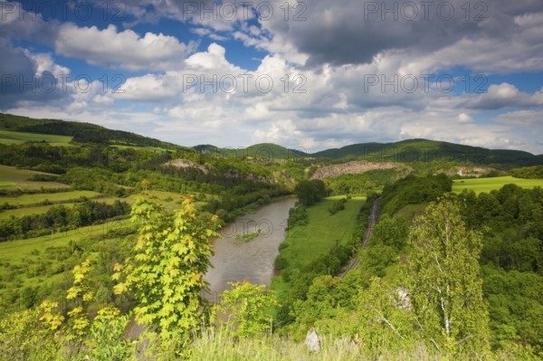 View from the hill into the valley with the Berounka river. Berounka river, limestone rocks, meadows, fields and railroad track