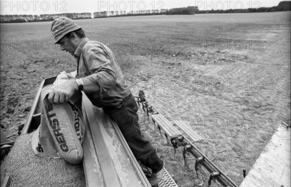 Germany, Eixen, 16.9.1991, tractor driver, farmer who has become self-employed, seed is being filled up