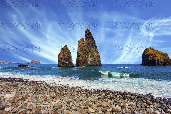 Three huge scenic rocks near the pebble beach. Concept of exotic and ecological tourism. Volcanic island of Madeira in the Atlantic Ocean. Warm summer day
