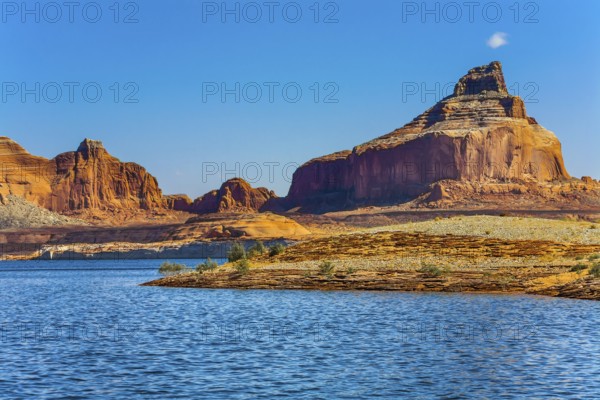 Huge picturesque lake with blue water, among outcrops of red sandstone. Lake Powell is a reservoir on the Colorado River, USA. Concept of active and photo tourism
