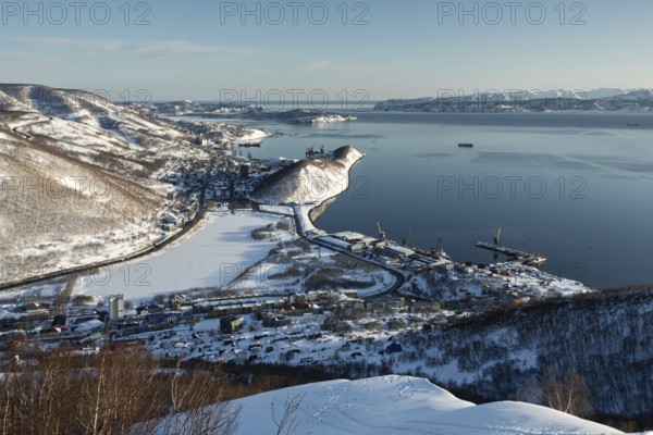 Beautiful winter Kamchatka landscape: top view of the Petropavlovsk-Kamchatsky City, Avacha Bay and Pacific Ocean at sunset. Far East, Russia, Kamchatka Peninsula. (Evening lighting.)