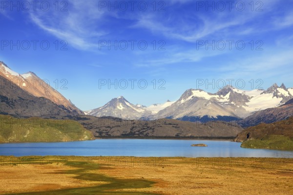 A blue lake in a picturesque valley surrounded by snow-capped mountains. National Park Perito Moreno in Patagonia, Argentina