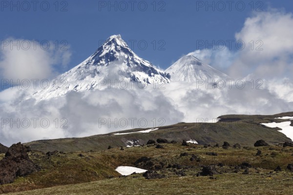 Beautiful mountain landscape of Kamchatka Peninsula: view on Kamen Volcano and active Klyuchevskoy Volcano on a sunny day. Russia, Far East, Kamchatka