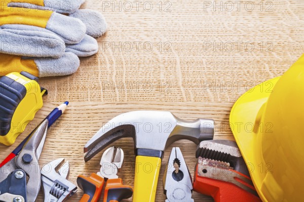 Organized copyspace set tools helmet wrench nippers pliers hammer cutter tapeline gloves on wooden board