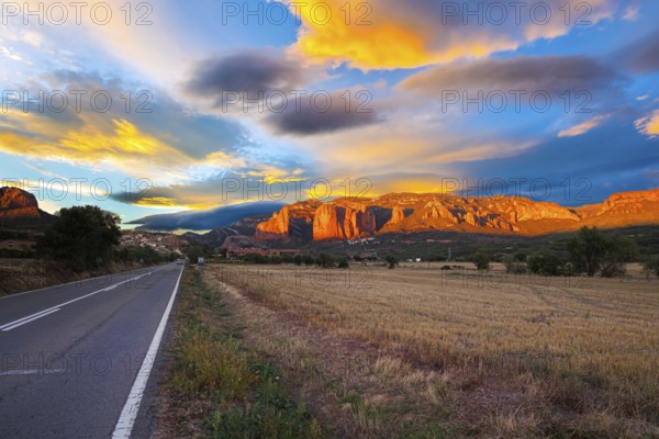 Red sunset. The magnificent Mallets of Riglos cliffs. Scenic paved highway. Romantic trip to Spain. Province of Huesca, Aragon. Mallets of Riglos is a conglomerate of rock formations
