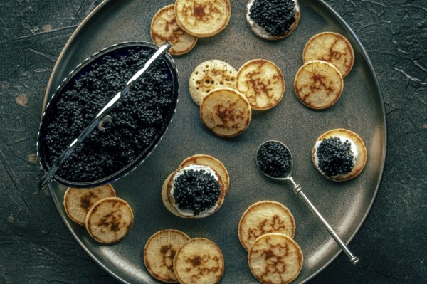 Blinis with caviar, overhead flat lay shot on a festive dish, mini pancakes, an elegant appetizer, Food photography, Food photography