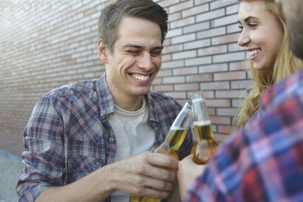Group of young best friends having fun with beer at street