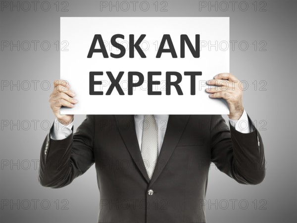 A business man holding a paper in front of his face with the text ask an expert