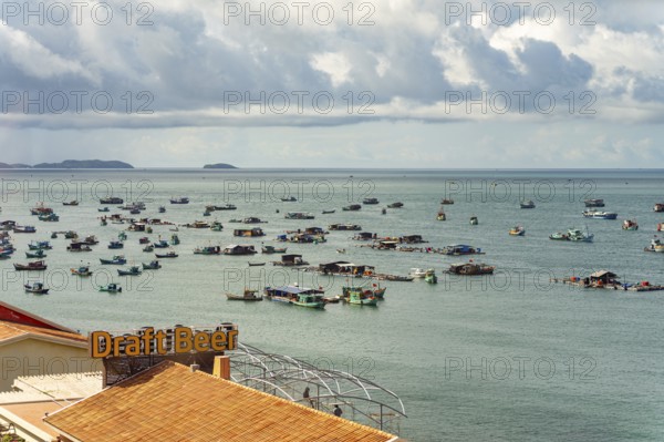 Calm sea with scattered boats and a cloudy sky in a coastal setting, palms, city, sun city, Phu Quoc, Vietnam