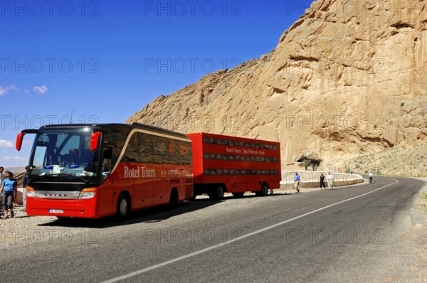 On the way to Erfound, A red coach stops next to a rocky road under a blue sky, Near Fes, Northern Morocco, Morocco