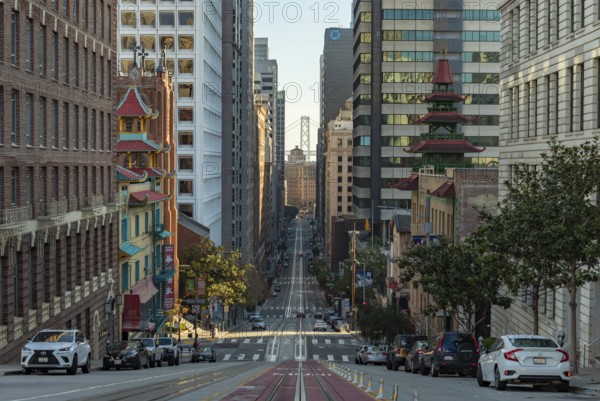 A picture of the long California Street, with Downtown San Francisco and the Oakland Bay Bridge at the far center. On the foreground there's also Chinatown
