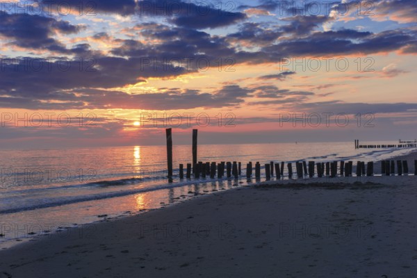 Beautiful Sunset at the seaside in the Netherlands with pastel colours in the clouds and the water