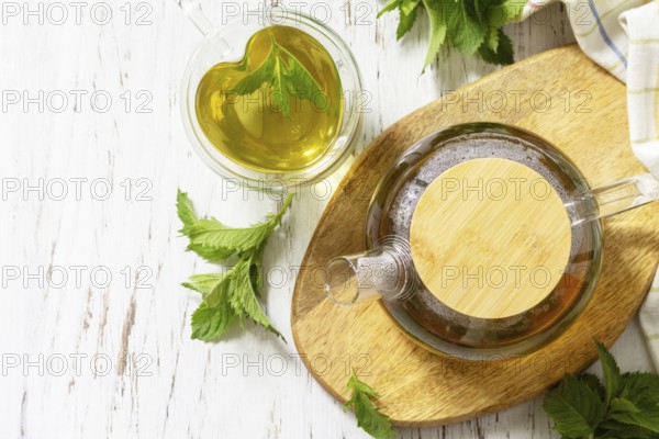 Cup and teapot of fresh natural herbal tea with fresh mint leaves on rustic wooden table. Organic aromatherapy relaxation medical healthy drink. View from above. Copy space