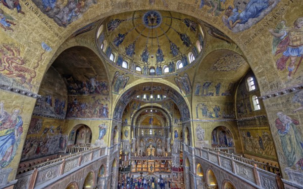 Upper view of a cathedral interior with vaulted ceilings adorned with gold mosaics and religious art, creating a grand and solemn atmosphere, Patriarchal Cathedral Basilica of Saint Mark commonly known as St Mark's Basilica, Venice, Veneto, Italy