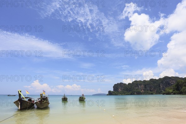 Light cirrus clouds over the warm sea. Picturesque native boat Longtail waiting on the beach the first tourists