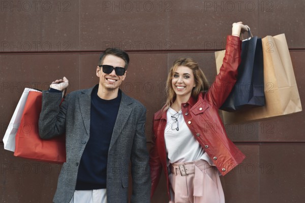 Beautiful young loving couple carrying shopping bags and enjoying together. Picture showing young couple shopping in the city