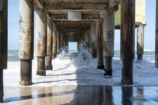 Dynamic ocean waves flowing under the sturdy pier