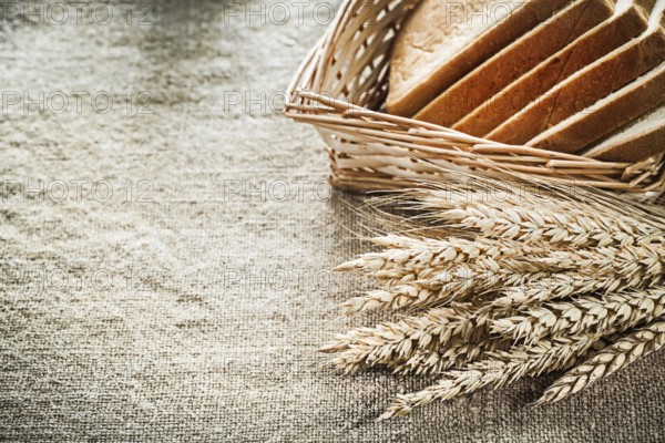 Wicker basket sliced toast bread rye ears on textured sacking background