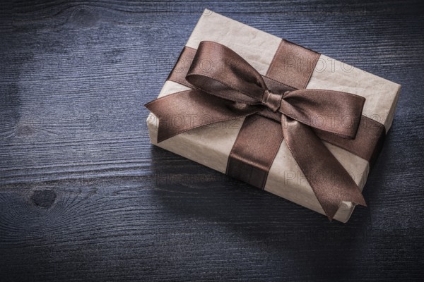 Gift box-container with bow on vintage wooden board