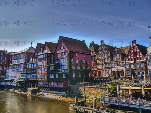 An atmospheric water scene with beautiful old half-timbered houses along the river on a sunny day, lüneburg, germany
