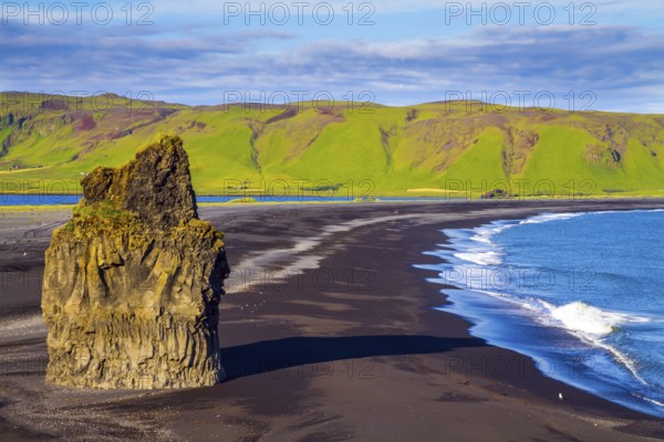 Cape Dyrholaey. Travel to the fabulous island of Iceland. Giant lonely rock - Palm on a black volcanic sand beach Reinisfjara. The concept of active, extreme and photo tourism